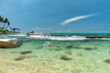 Sunny beach near Koggala - Sri Lanka. Waves of clear water and warm sand 