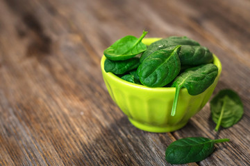 Baby spinach leaves on old rustic table