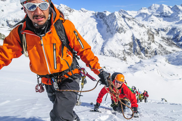 Bergführer mit Seilschaft im Aufstieg im Schnee