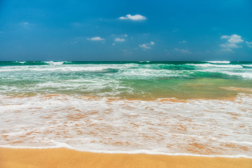 Sunny beach near Koggala - Sri Lanka. Waves of clear water and warm sand 