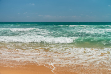Sunny beach near Koggala - Sri Lanka. Waves of clear water and warm sand 