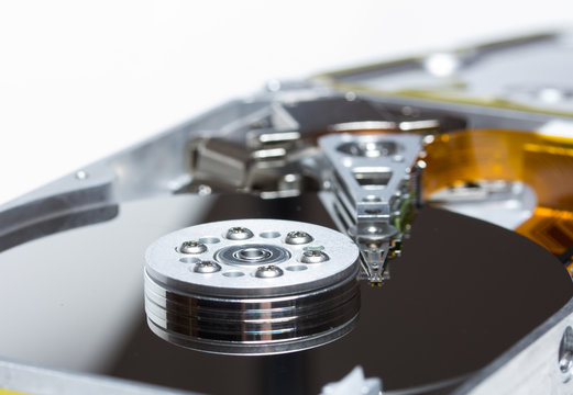 Close-up of an open hard disk drive showing shiny platters and actuator arm, symbolizing data storage and technology.