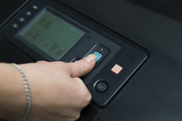 Woman with his finger on the start key and ready to make a print