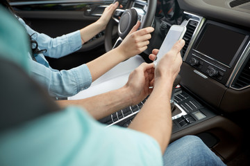 happy man and woman with smartphone driving in car