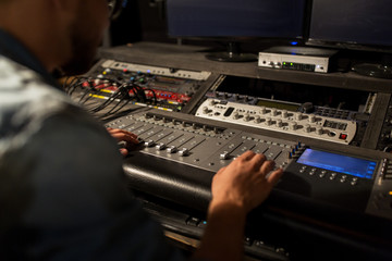 man using mixing console in music recording studio