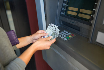 close up of hand withdrawing money at atm machine