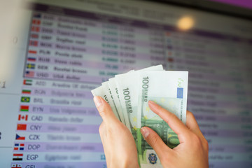hands with euro money over currency exchange rates