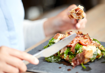 woman eating prosciutto ham salad at restaurant