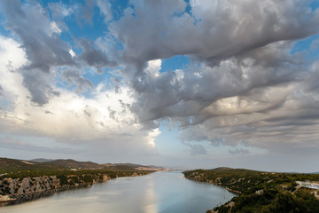 Unusual 3D clouds in the sky over the sea strait.