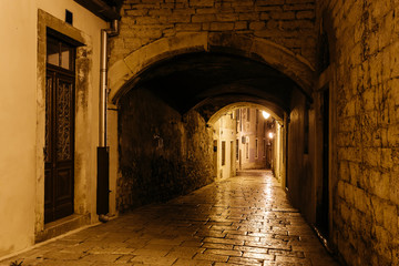 empty night narrow European street with archway in the center of Sibenik, Croatia.