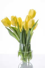 Yellow tulips flowers bouquet in a glass vase