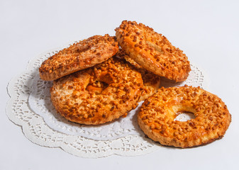 Rings of dough sprinkled with walnuts on a napkin.