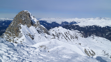 Alpine snowy peaks panorama, skiing piste on an edge of a rock, Meribel resort, 3 Valleys, Alps, France