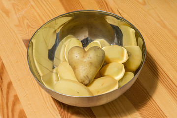 Herzförmige Kartoffel in einer Schüssel mit anderen Kartoffeln