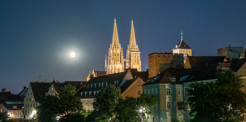 Fototapeta premium Nachtaufnahme von Regensburg mit Mond neben dem Dom