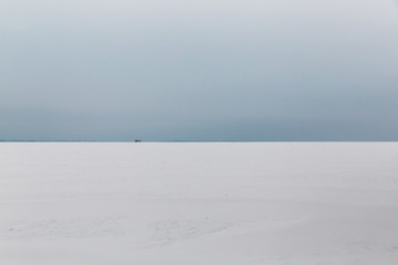 The gloomy winter sky over the snowy field.