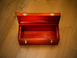 Empty red tool box on wooden floor