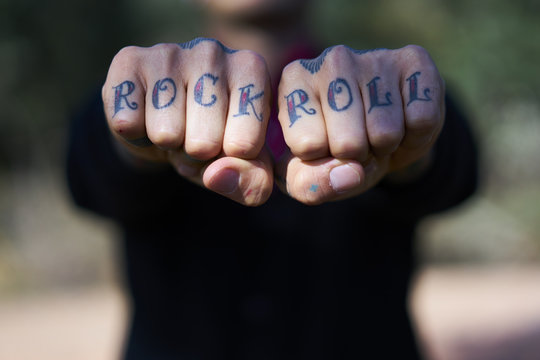 Fingers tattooed with 'Rock and Roll'