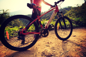 Fototapeta na wymiar young woman riding bike on forest mountain trail