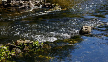 A wide stream flows over the rocks.