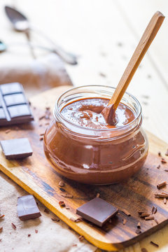 Organic Nutella Cream in Glass Jar on Light Wooden Table, Vertical View