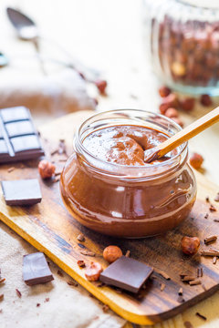 Homemade Paleo Hazelnut and Chocolate Cream in Jar on Light Wooden Table, Vertical View