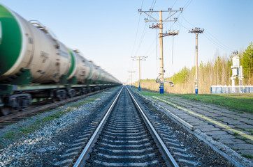 Fototapeta na wymiar Train with oil tanks moving. Transportation of fuel on the railroad. Motion blur.