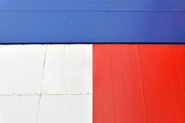 Geometric architectural background. Detail of the facade of red, blue and white panels. Front view.