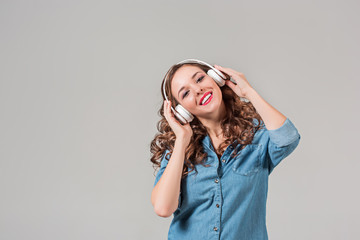 Happy young woman listening music with headphones.