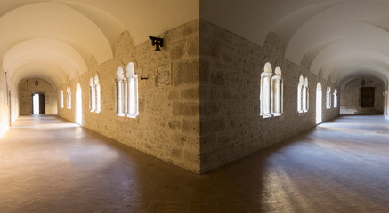 Gallerie in pietra del chiostro di un convento tra giochi di luce