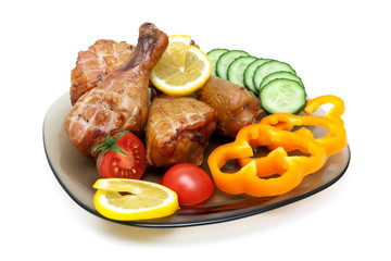 Grilled chicken legs with vegetables on a plate.