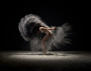 Dancer moving in cloud of white dust at studio