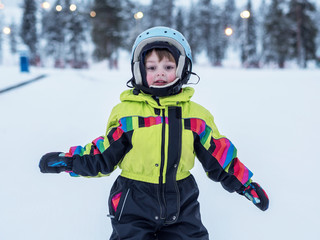 Fototapeta na wymiar Child learn skiing in the mountains. Toddler kid in helmet learn