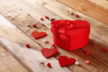 Red hearts and present box on wooden table