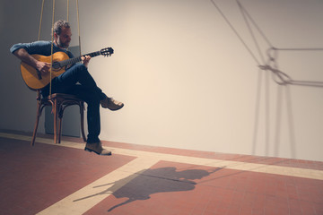 Man plays a guitar, interior
