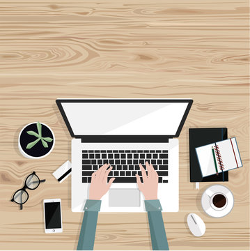 Freelance work.Desktop with with isolated laptop, notebooks, coffee, glasses, credit card and freelancer's hands typing. Top view. Wood background. Vector flat illustration