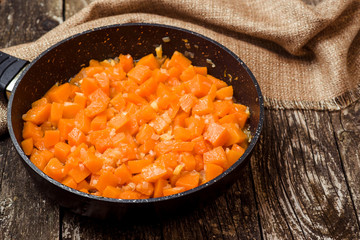 Roasted pumpkin on the pan over dark wooden background.
