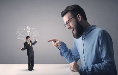 Young businessman fighting with miniature businessman