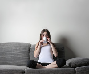 Girl drinking on sofa 