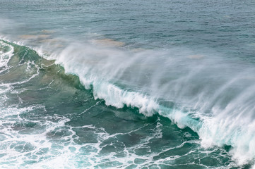 Fototapeta premium Massive waves, green turquoise colored, rolling in at a surf break on Fuerteventura Canary Islands.