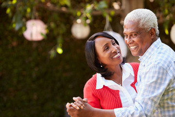 Senior black couple dancing in their backyard, close up