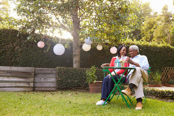 Senior African American couple sitting in their back garden