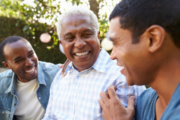 Senior man talking with his adult sons in garden, close up - Powered by Adobe