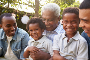 Multi generation male family members gathered in a garden