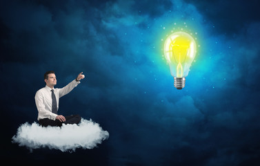 Man sitting on cloud looking at a lightbulb