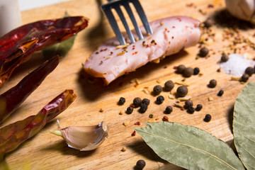 Fork with a slice of bacon on board herbs