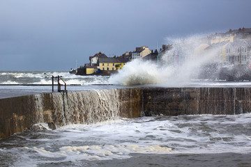 A winter storm buffets the pier at the Long Hole harbor in Bangor Northern ireland sending foam and spray into the air