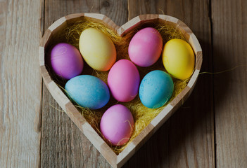 Easter eggs in a wooden heart shaped bowl