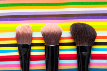 make up brushes on a bright colorful striped background