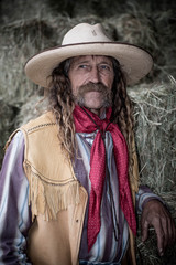 Western cowboy portrait with red necktie, leather vest 